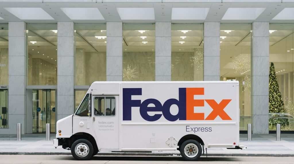 A FedEx Truck in front of a glass building entrance